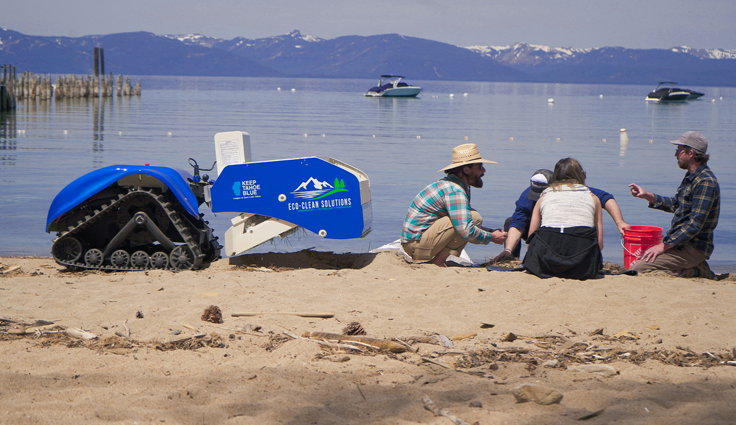 The beach-cleaning robot and staff on the beach.