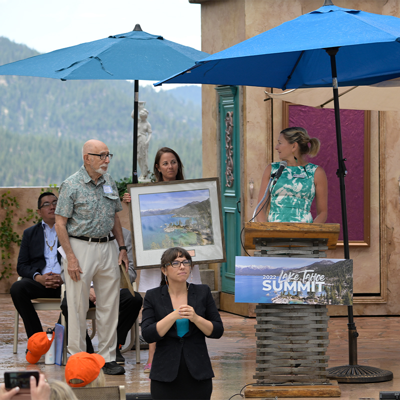 Darcie Collins presents an award to Dr. Charles Goldman at the 2022 Tahoe Summit.